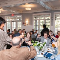 President Mantella raising a glass with a table